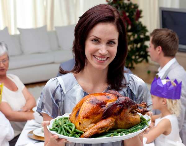 Woman showing Christmas turkey for family dinner
